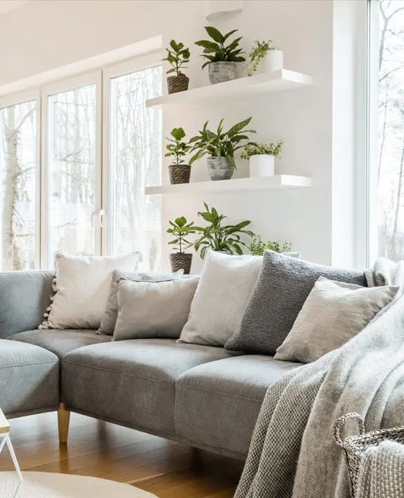 A living room with many pillows on the couch