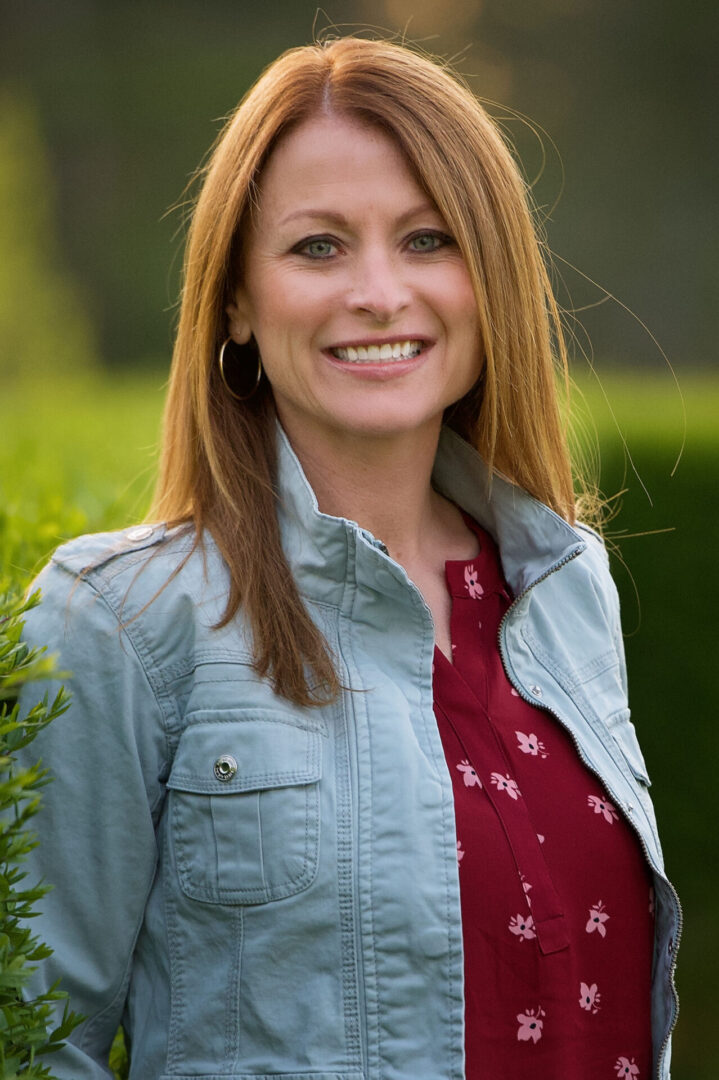 A woman in a red shirt and blue jacket